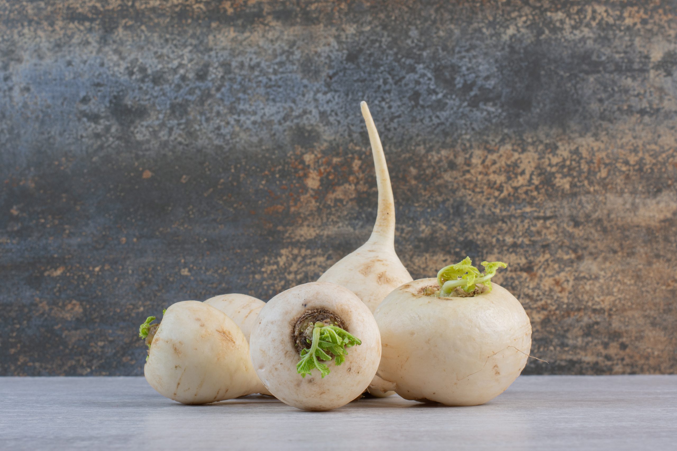 Raw white turnips on stone table